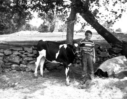 Jonathan holding calf in front of rock wall